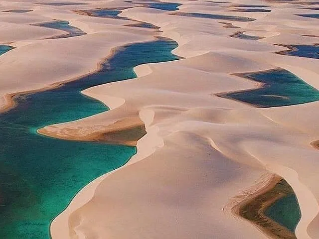 Luftaufnahme der weißen Sanddünen und türkisfarbenen Lagunen in den Lençóis Maranhenses.